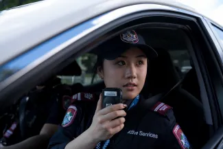 Protective Services Officer in car on radio